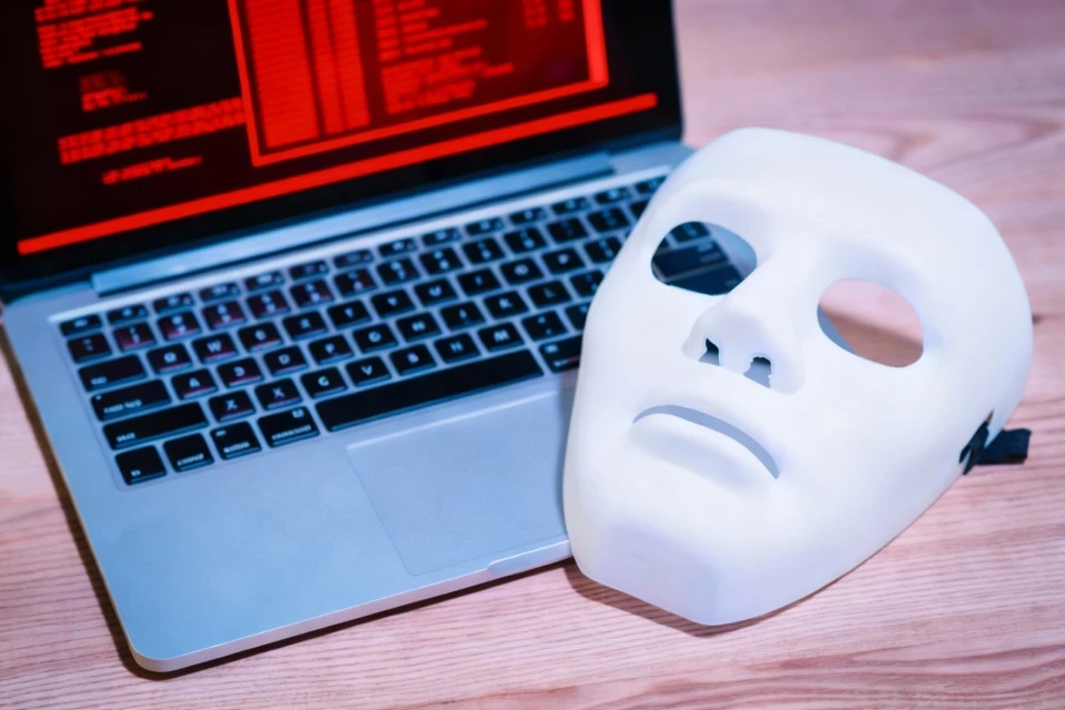 Detail na bílou masku položenou přes klávesnici notebooku